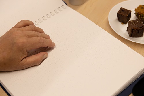 A hand on a page of braille