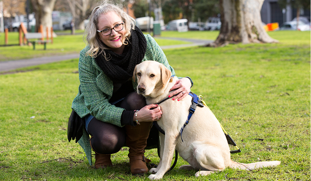 Client kneeling next to her light seeing eye dog.