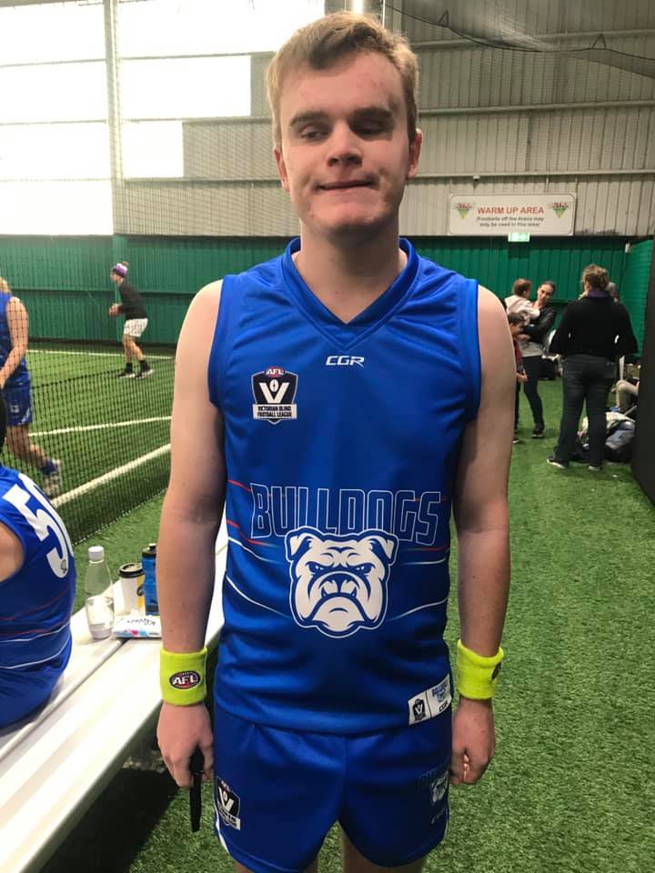 Caleb standing in an indoor AFL arena wearing his uniform