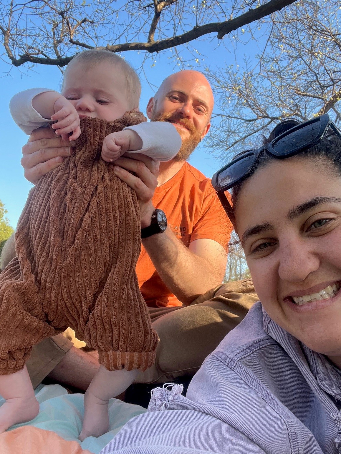 "Lauren, Chris and Eddy on a sunny day, outdoors under a tree."