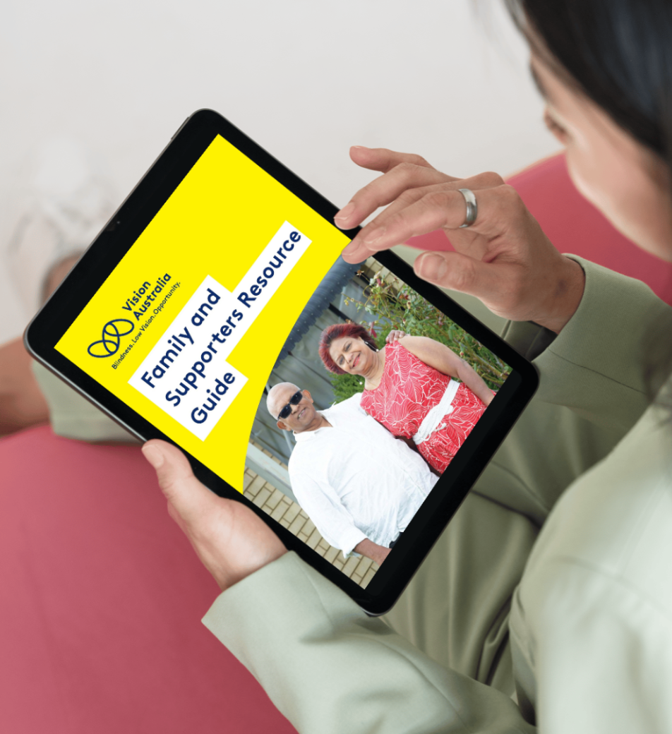 A woman holds an electronic tablet as she reads Vision Australia’s Family and Supporters Resource Guide.