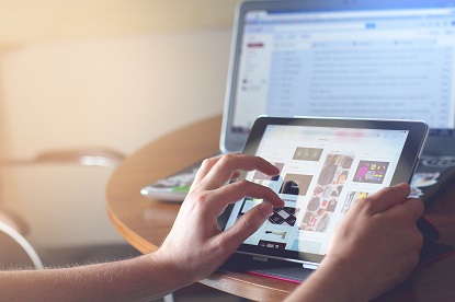 A person uses an iPad at a desk