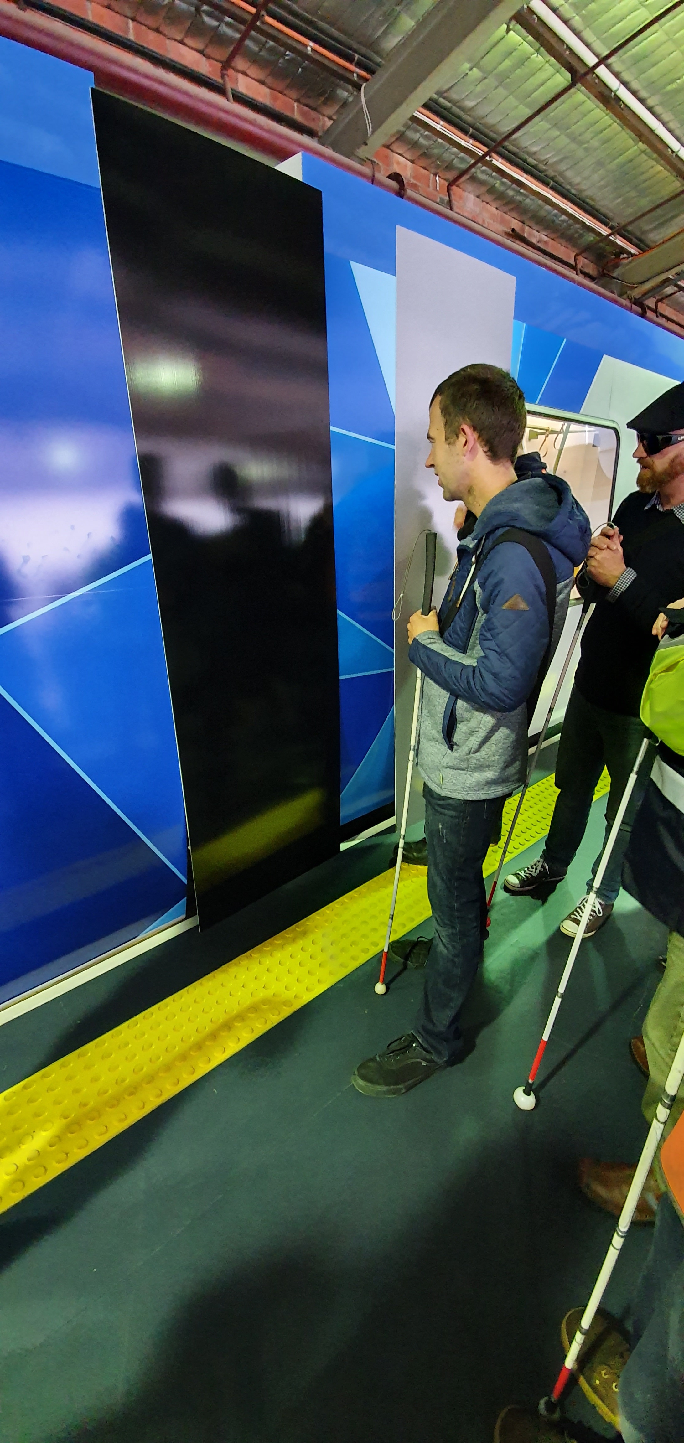 "Shane, a Vision Australia client, looks at the different colours being trialed to cover the gangways between carriages. "